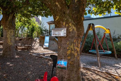 Spielbereich draußen mit Rutsche und Schaukel