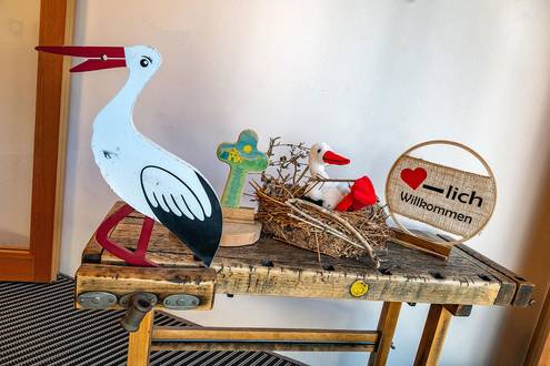 Willkommensschild und Störche als Kuscheltier und aus Holz